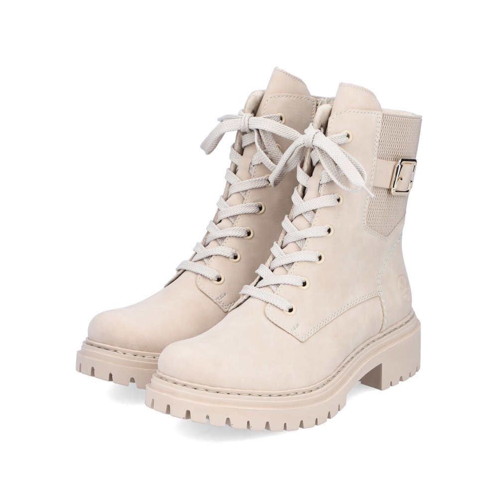 Beige Rieker women´s biker boots 72631-63 with decorative buckle as well as zipper. Shoes laterally.