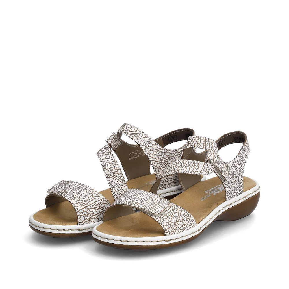 White Rieker women´s strap sandals 659C7-81 with a hook and loop fastener. Shoes laterally.
