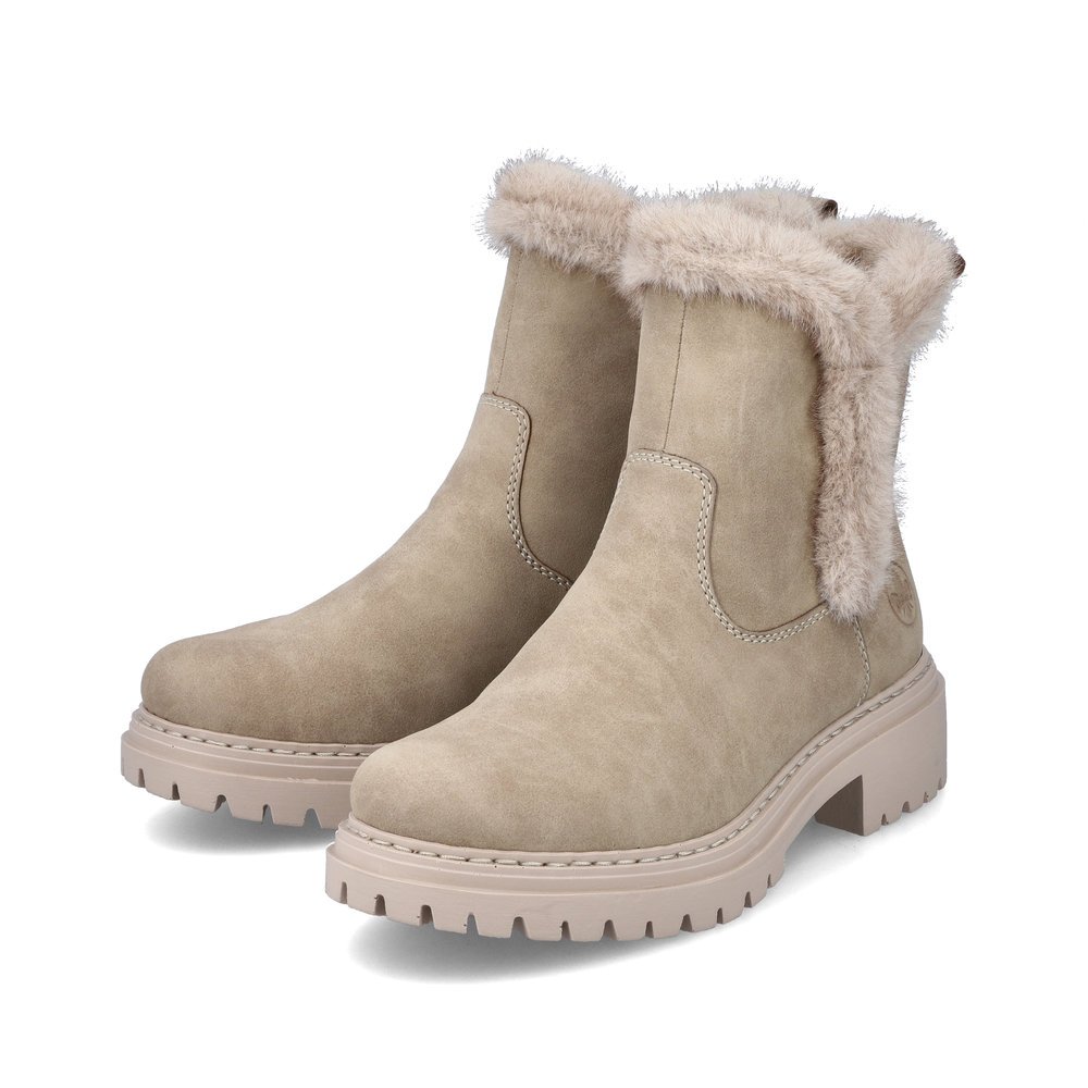 Sandbeige Rieker Damen Kurzstiefel 72682-60 mit Fell-Design sowie Reißverschluss. Schuhpaar seitlich schräg.