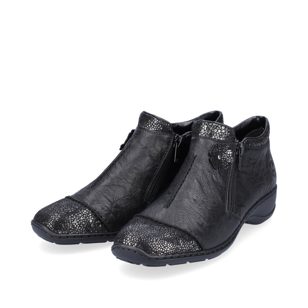 Bottines Rieker noires pour femme 58388-01 avec fleur décorative. Chaussures inclinées sur le côté.