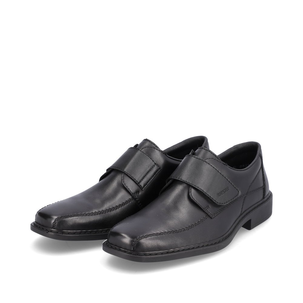 Rieker chaussons noirs hommes B0853-00 avec une fermeture velcro. Chaussures inclinée sur le côté.
