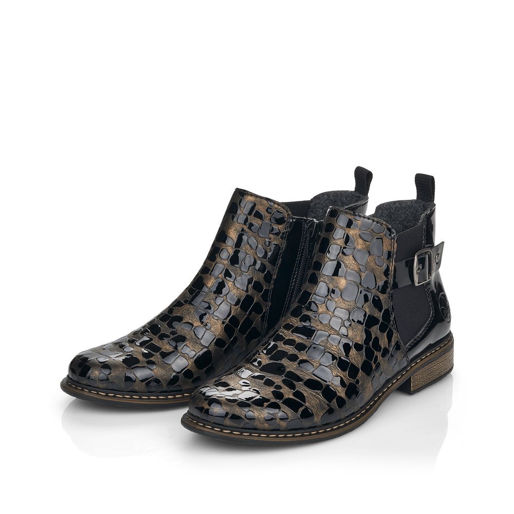 Bottes Chelseas Rieker noires pour femme Z4965-90 avec boucle décorative. Chaussures inclinées sur le côté.