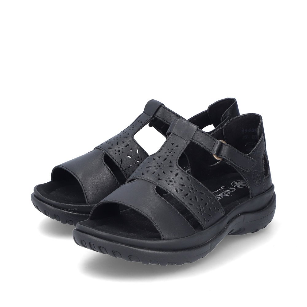 Rieker sandales à lanières noires femmes 64865-01 avec fermeture velcro. Chaussures inclinée sur le côté.
