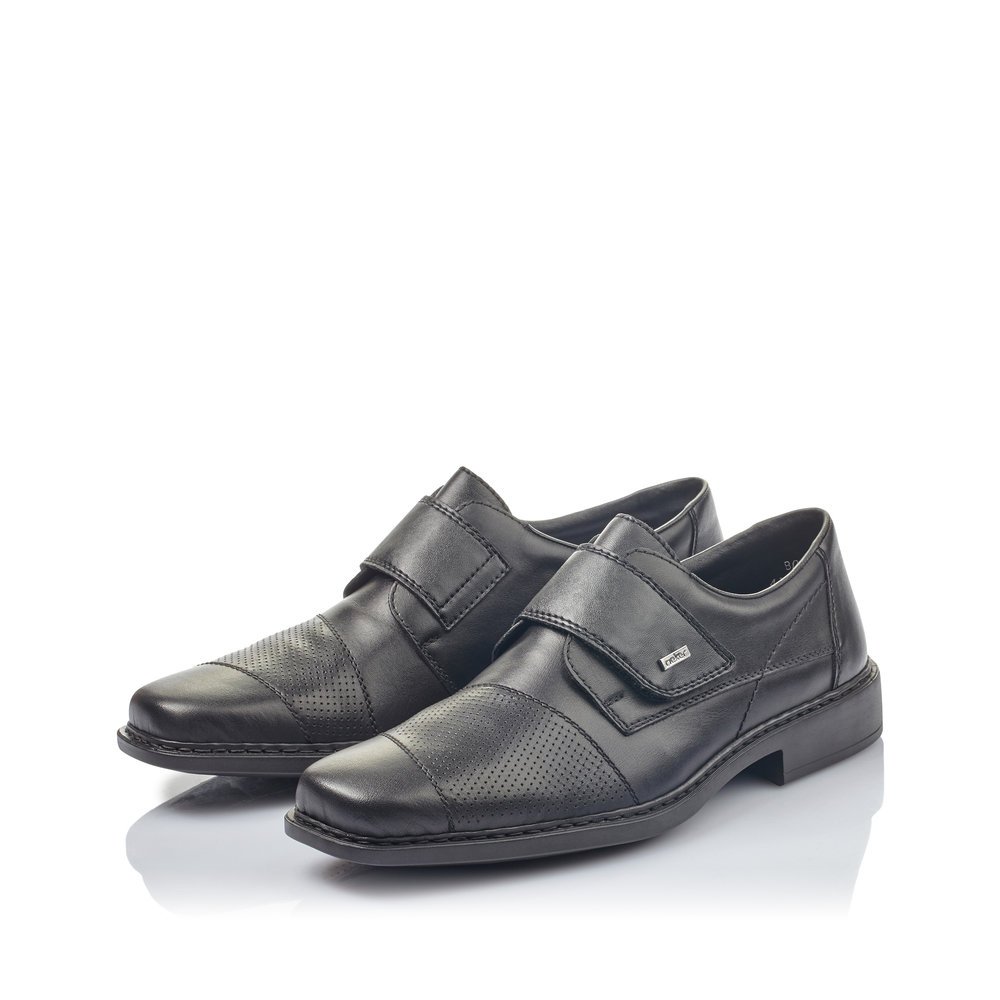 Rieker chaussons noirs pour hommes B0857-00 avec une fermeture velcro. Chaussures inclinée sur le côté.