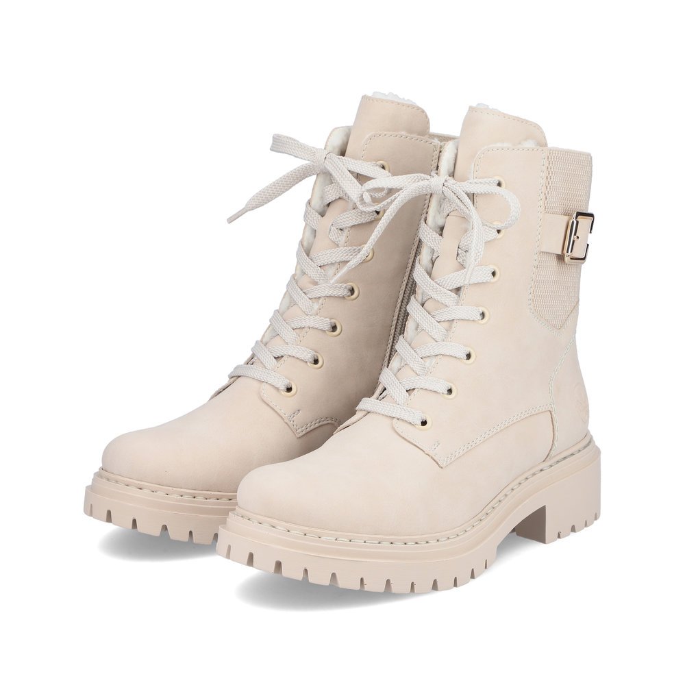 Beige Rieker Damen Biker Boots 72631-62 mit Zierschnalle sowie Reißverschluss. Schuhpaar seitlich schräg.