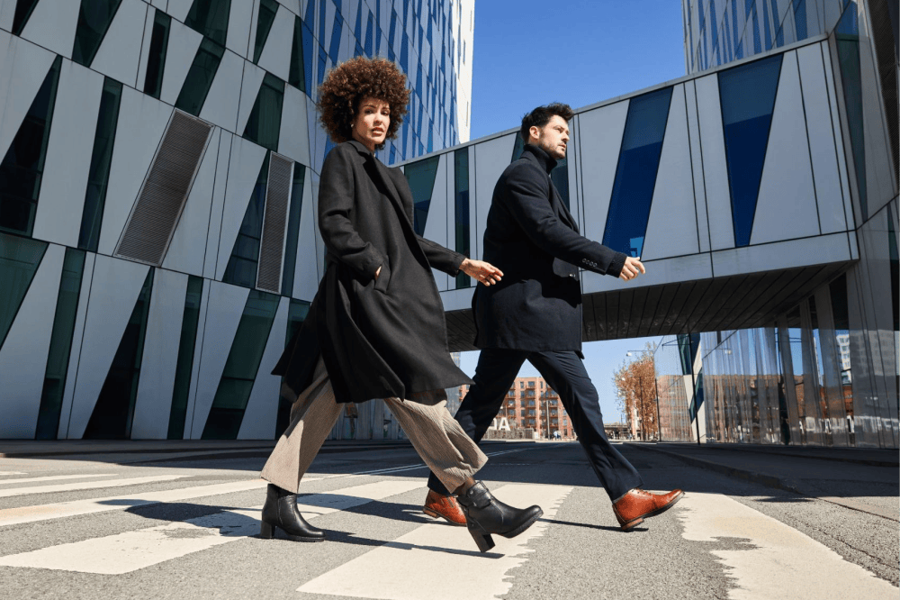 La femme et l\'homme portent des chaussures de ville de la marque Rieker. Rieker.