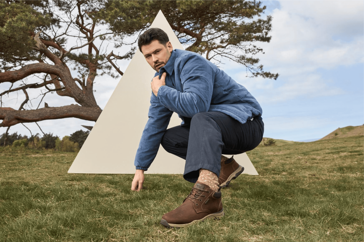 L\'homme tient des chaussures d\'automne 31204-22 de Rieker.