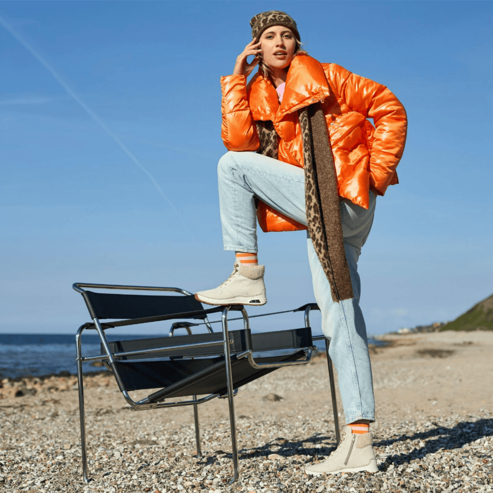 La femme tient des bottes à lacets 44555-60 de Rieker.