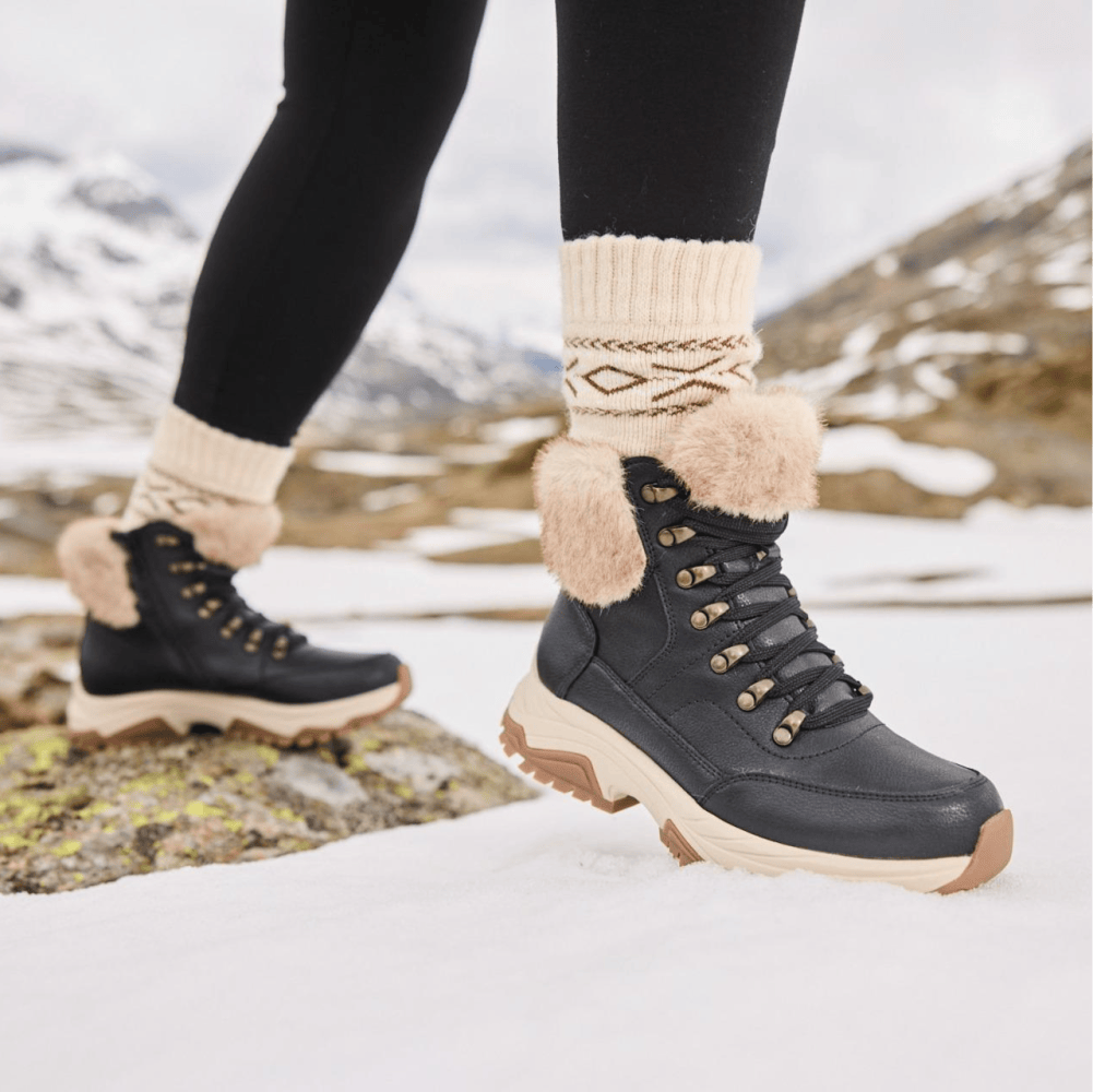 Femme portant des bottines marron Rieker w3971-00 avec semelle thermique.