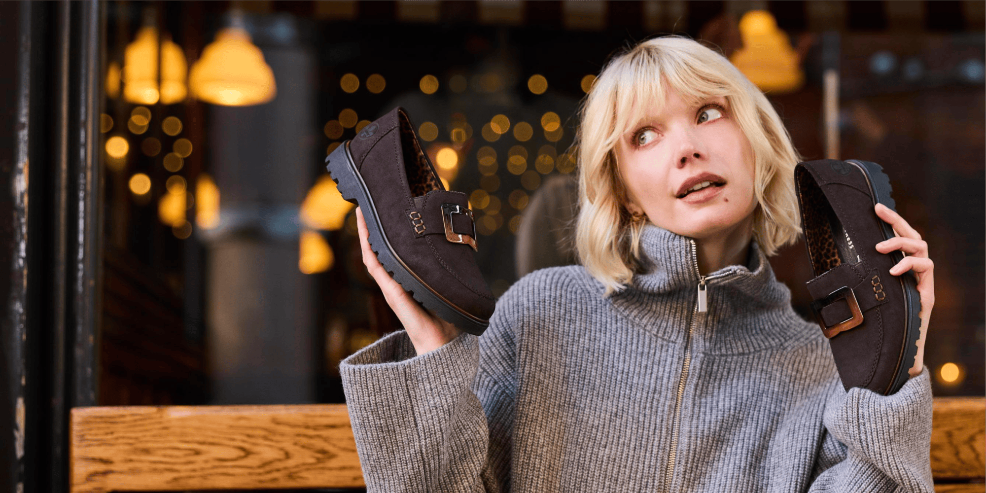 Woman holds Rieker Woman Loafer in her hands.