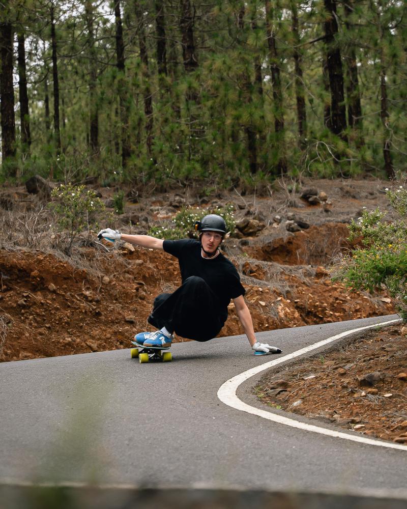 Downhill Skateboarder faehrt den Berg runter mit Rieker Schuhen