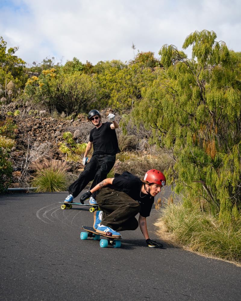 zwei Downhill Skateboarder fahren den Berg runter mit Rieker Schuhen