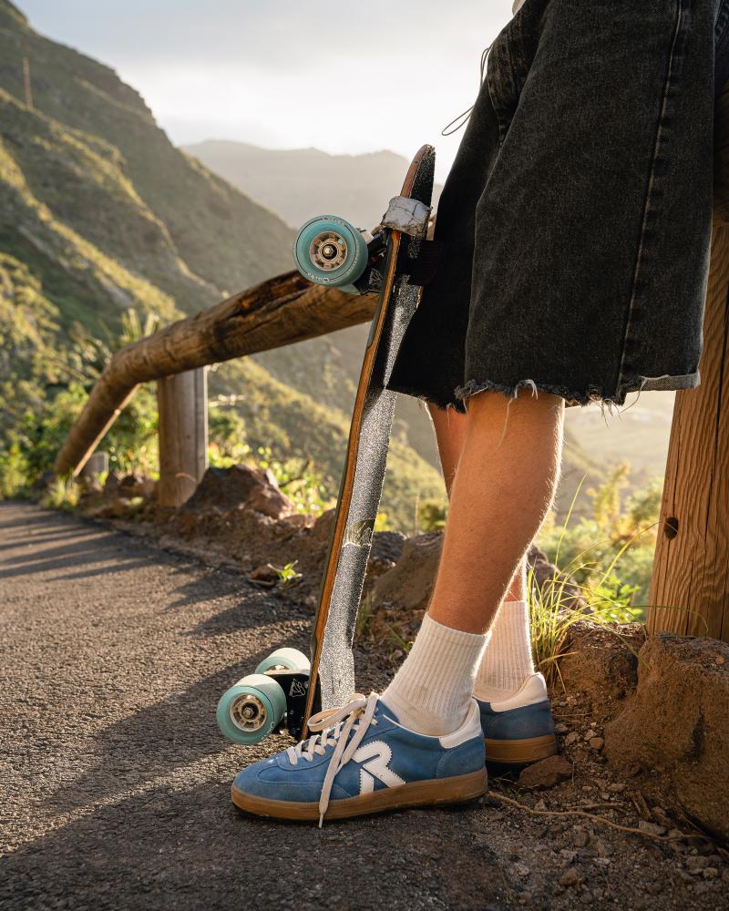 Retro Herren Sneaker von Rieker in blau neben einem Skateboard
