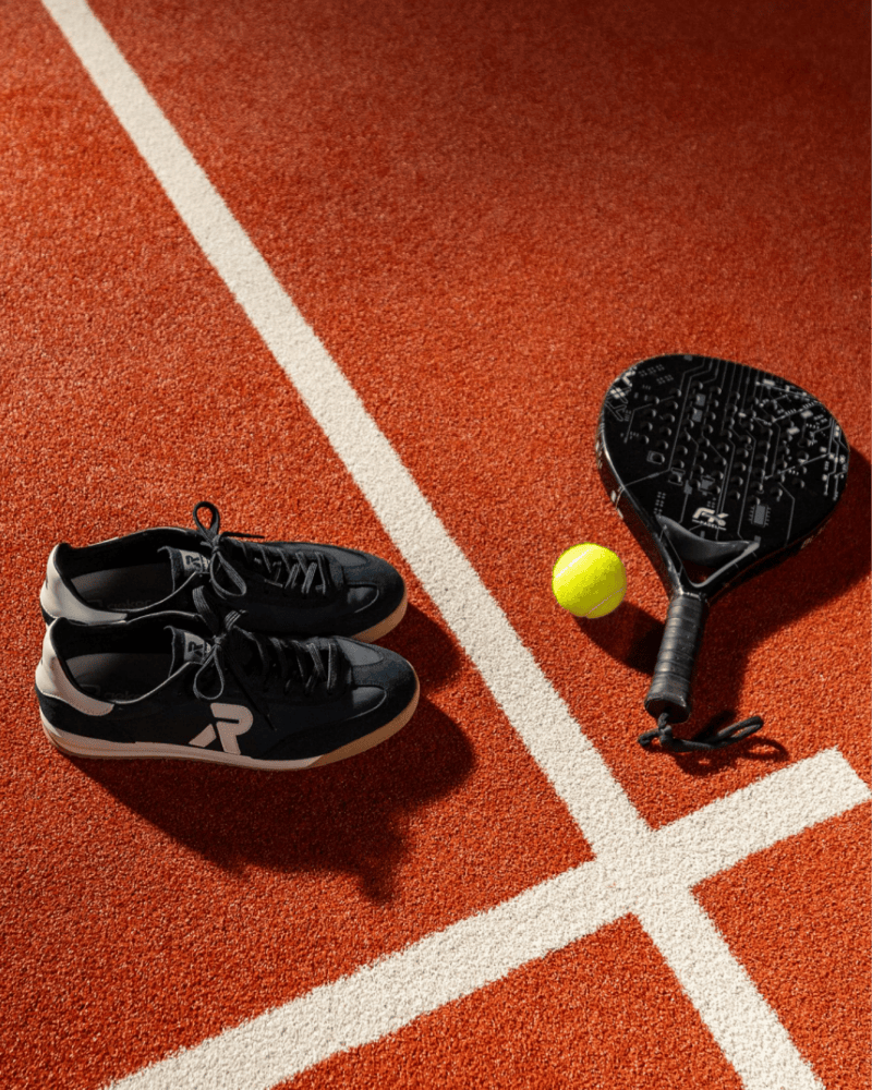 sportliche Herren Retro Sneaker in dunkelblau auf einem Padel Court