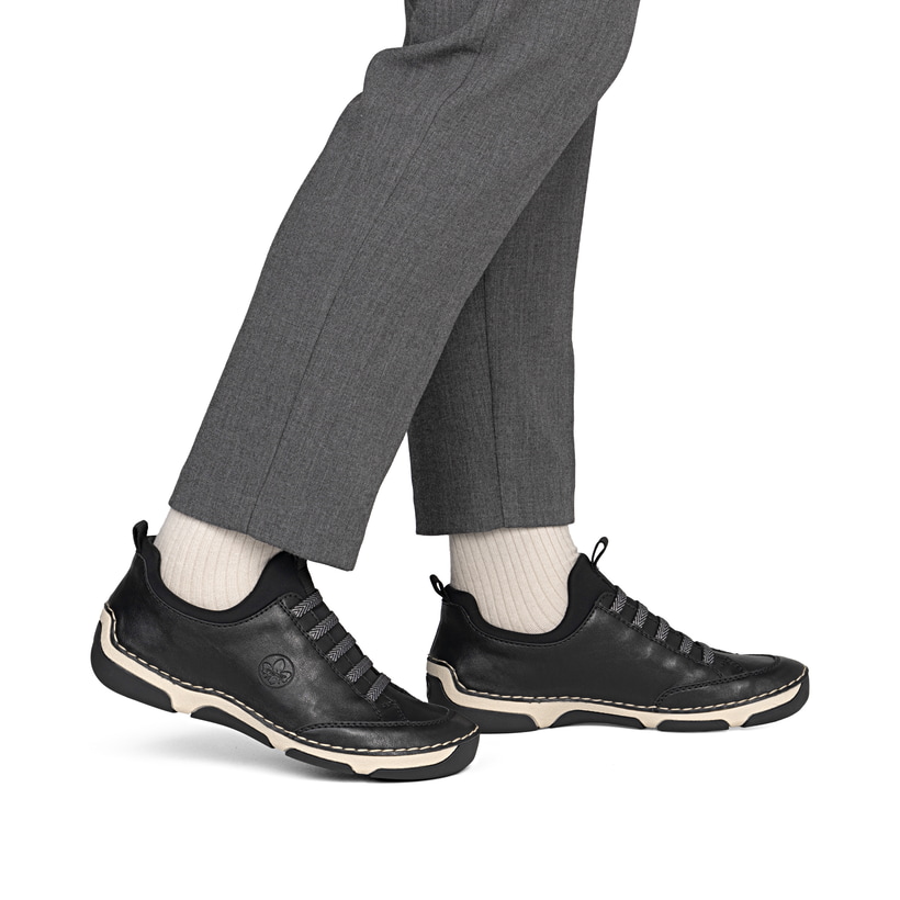 Schwarze Rieker Damen Slipper 55952-00 mit einem Gummizug. Schuh am Fuß.