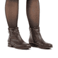 Dunkelbraune Rieker Damen Stiefeletten 77041-26 mit Zierelement. Schuh am Fuß.