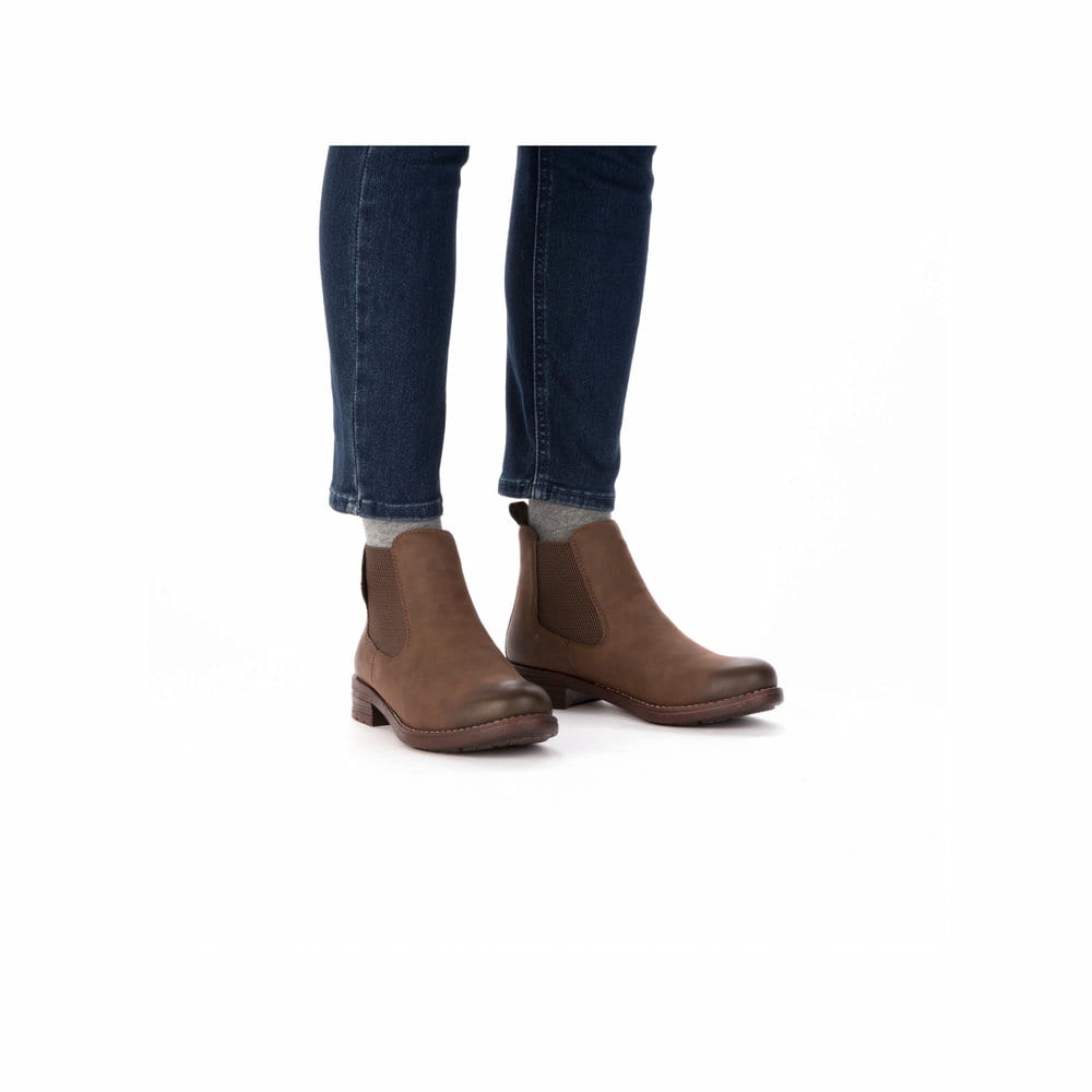 Dunkelbraune Rieker Damen Chelsea Boots 79450-24 mit einem Gummizug. Schuh am Fuß.