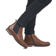 
Nussbraune Rieker Herren Chelsea Boots 14653-24 mit einer robusten Profilsohle. Schuh am Fuß
