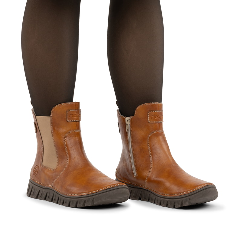 Braune Rieker Damen Chelsea Boots 57560-24 mit einem Reißverschluss. Schuh am Fuß.