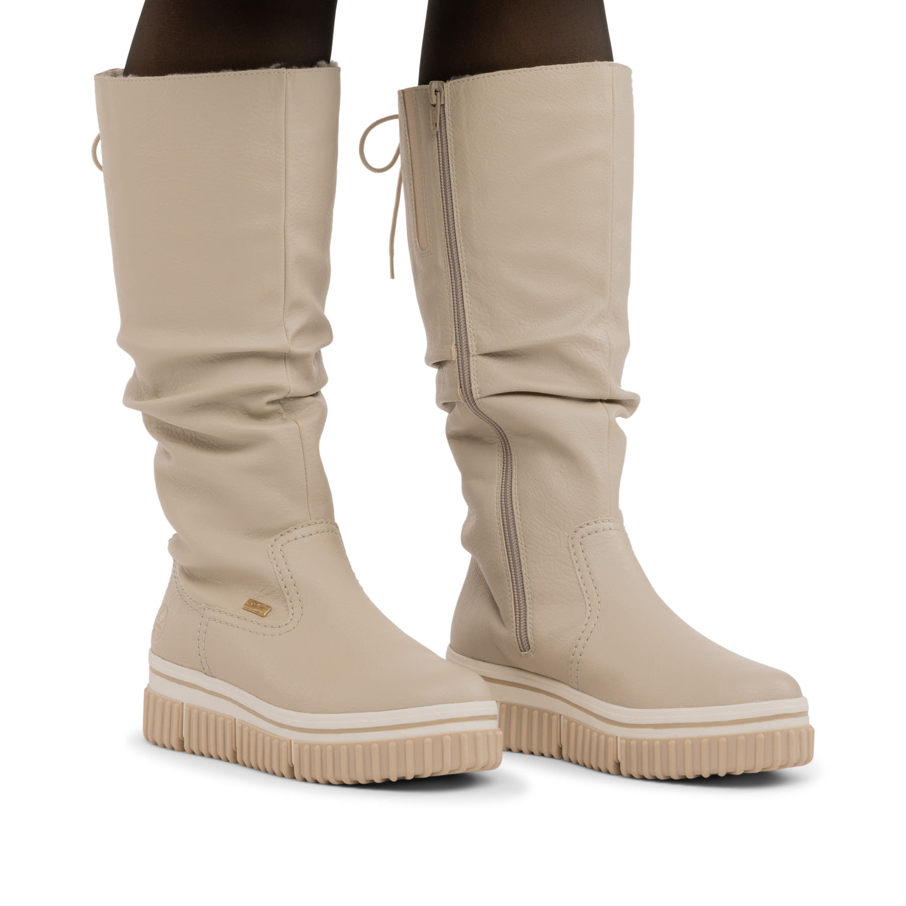 Cremefarbene Rieker Damen Hochschaftstiefel Y6370-60 mit gerafftem Schaft. Schuh am Fuß.