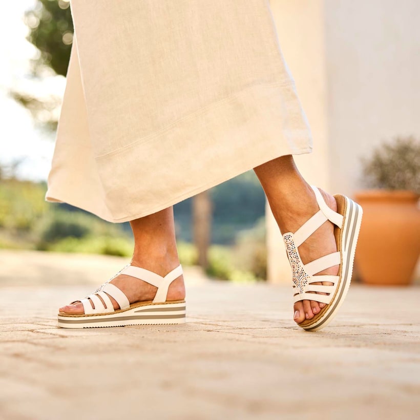 Weiße Rieker Keilsandaletten V0240-80 mit Strasssteinen sowie einem Gummizug. Schuh am Model.