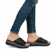 Schwarze Rieker Damen Pantoletten V2351-00 mit floralem Muster. Schuh am Fuß.