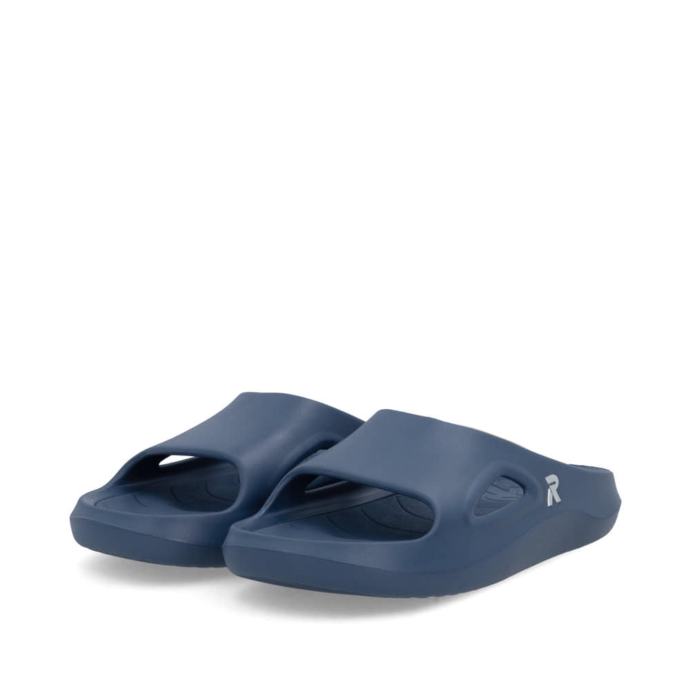 Mules Rieker bleues homme U3450-14 avec semelle ultra légère et flexible. Chaussures inclinées sur le côté.
