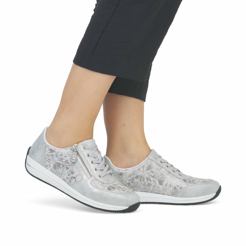 Baskets basses Rieker blanches pour femme N1112-80 avec motif floral. Chaussure au pied.
