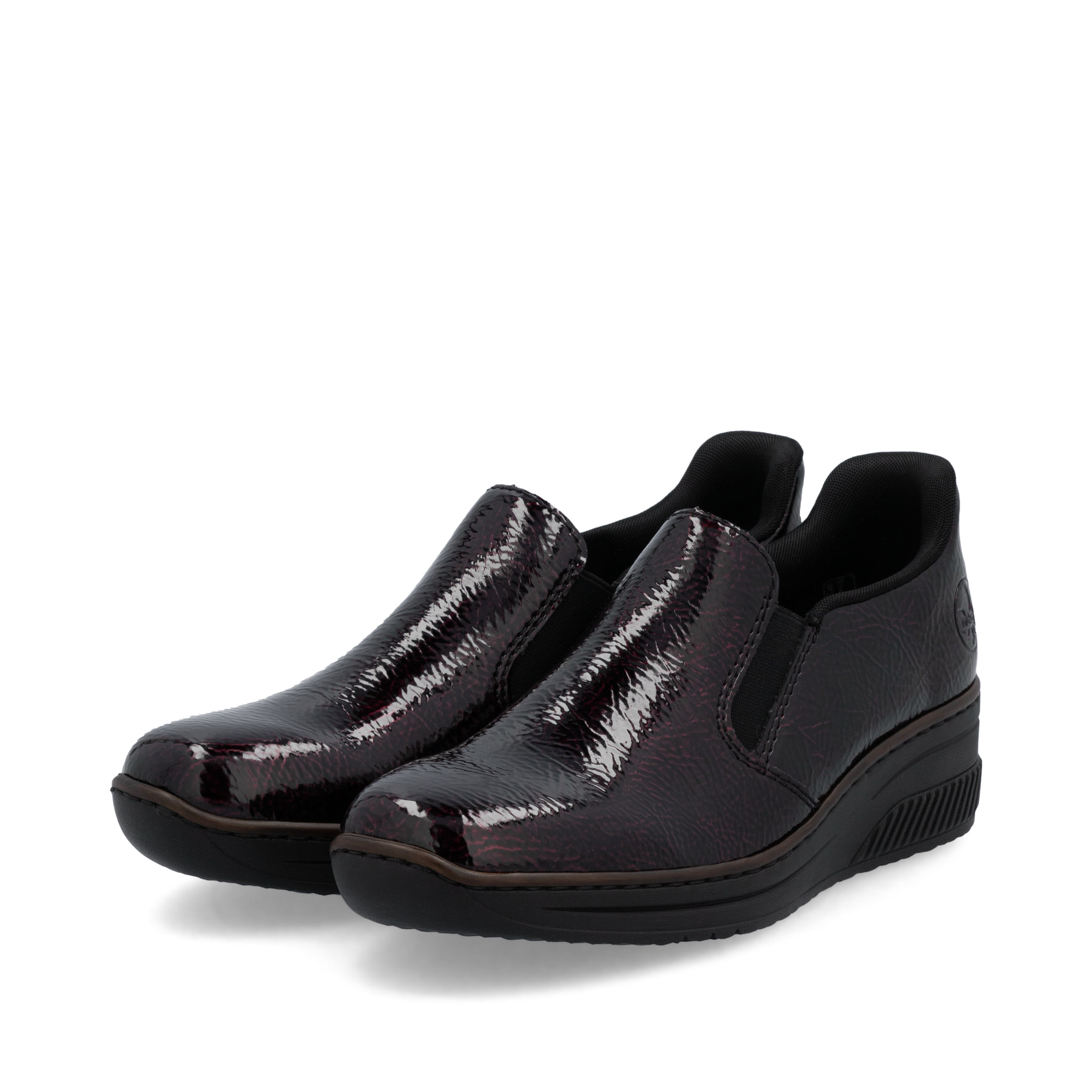 Rote Rieker Damen Slipper 48761-35 mit einem Gummizug sowie schmaler Passform E. Schuhpaar seitlich schräg.