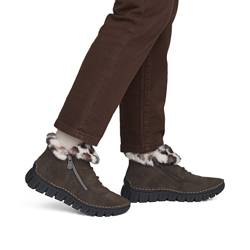 Dunkelbraune Rieker Damen Kurzstiefel 57551-25 mit weichem Kragen. Schuh am Fuß.