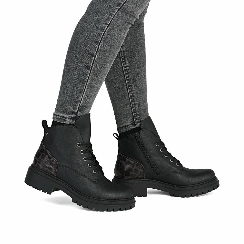 Schwarze Rieker Damen Biker Boots 72602-00 mit Leo-Print sowie einer Schnürung. Schuh am Fuß.