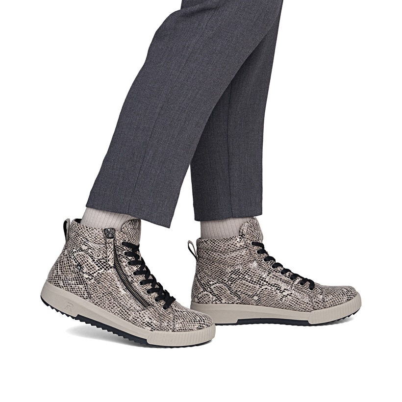 Beige-schwarze Rieker Damen Sneaker High W0164-64 mit modernen Ziernähten. Schuh am Fuß.