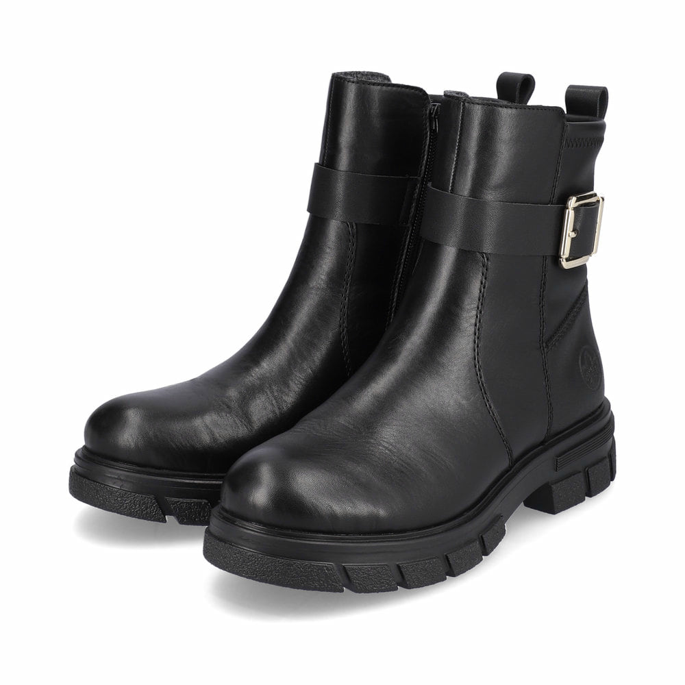 Schwarze Rieker Damen Kurzstiefel Z9174-00 mit Zierschnalle sowie Reißverschluss. Schuhpaar seitlich schräg.