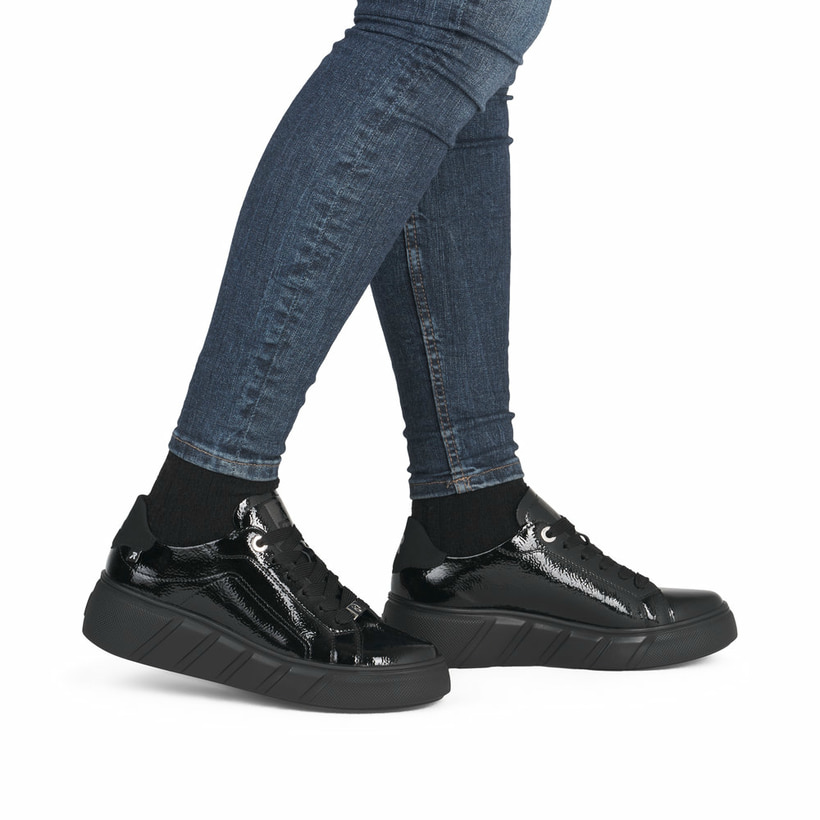 Schwarze Rieker Damen Sneaker Low W2601-00 aus Lackleder mit einer Schnürung. Schuh am Fuß.