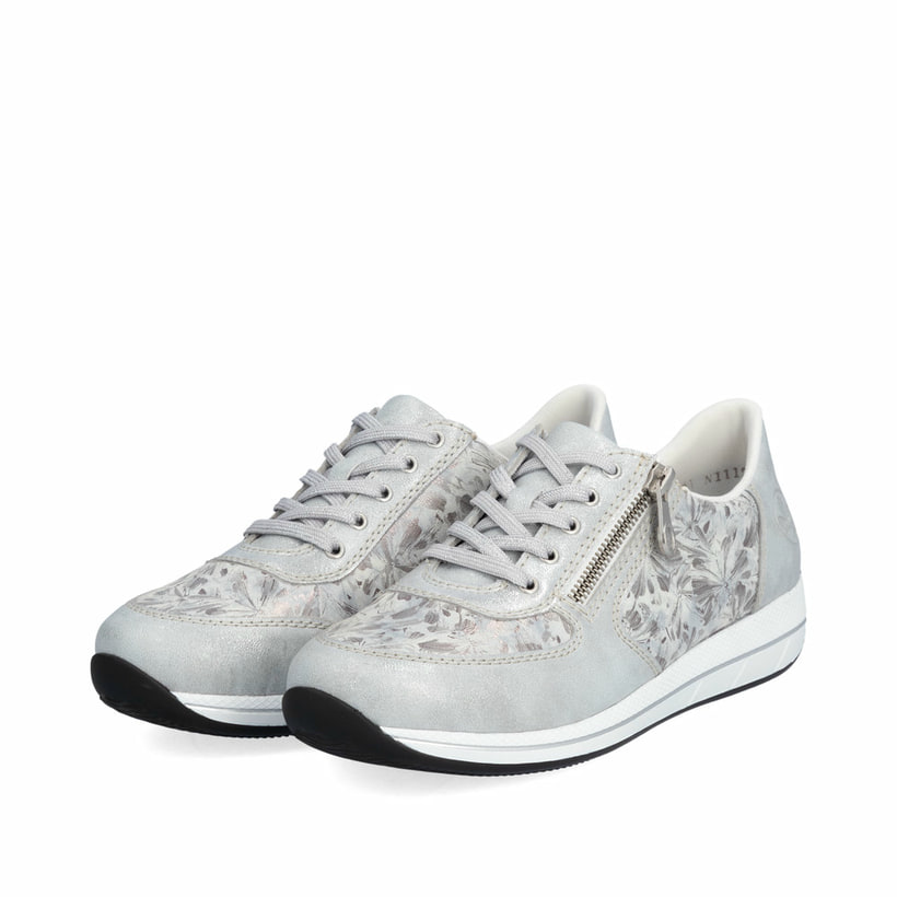 Baskets basses Rieker blanches pour femme N1112-80 avec motif floral. Chaussures inclinées sur le côté.