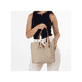 Rieker Handtasche H1045-60 in Beige mit einer Schleife aus dünnem Stoff am Henkel und geräumigem Hauptfach. Handtasche getragen.