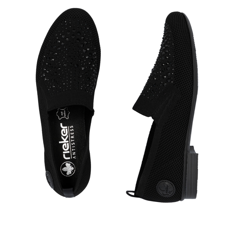 Schwarze Rieker Damen Slipper 51989-00 mit Strasssteinen sowie einem Gummizug. Schuh von oben, liegend.