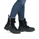 Schwarze Rieker Damen Kurzstiefel W2175-00 aus Rauleder mit weißer Zickzack-Naht. Schuh am Fuß.