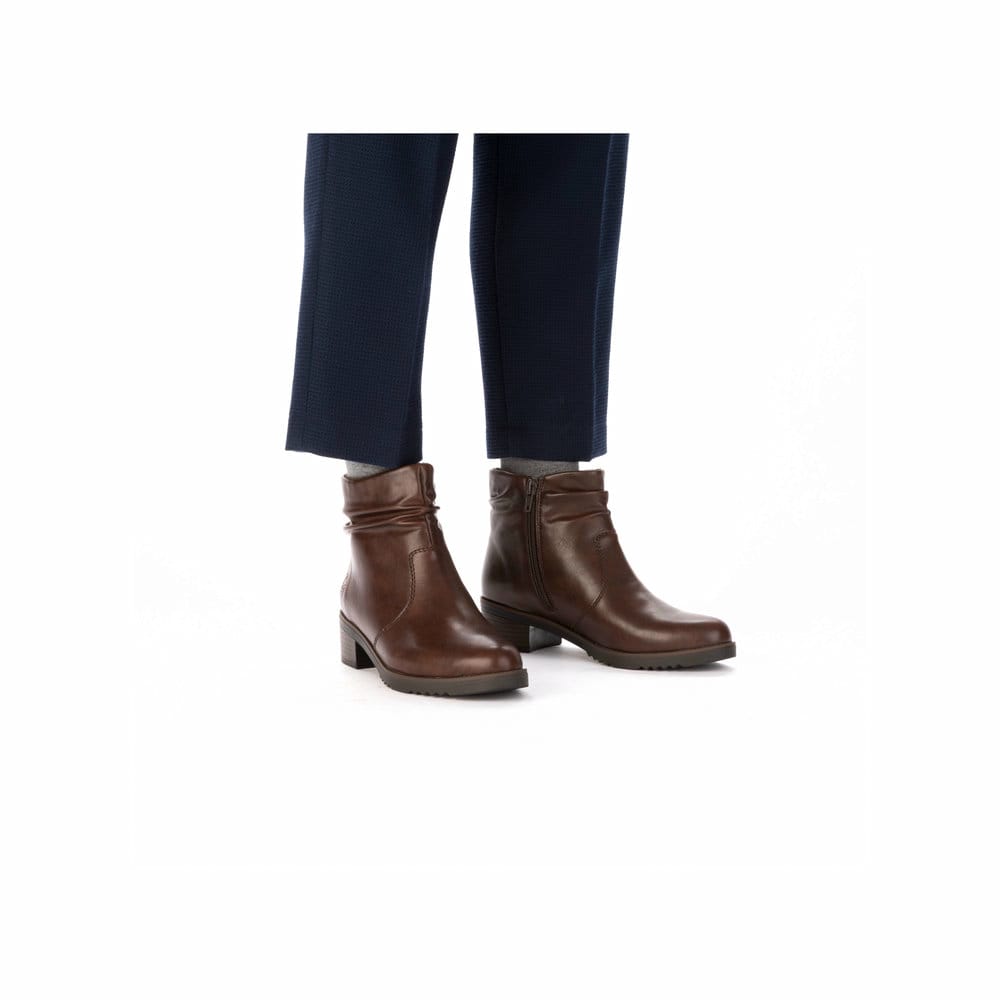 Dunkelbraune Rieker Damen Stiefeletten Y0551-25 mit einem Reißverschluss. Schuh am Fuß.