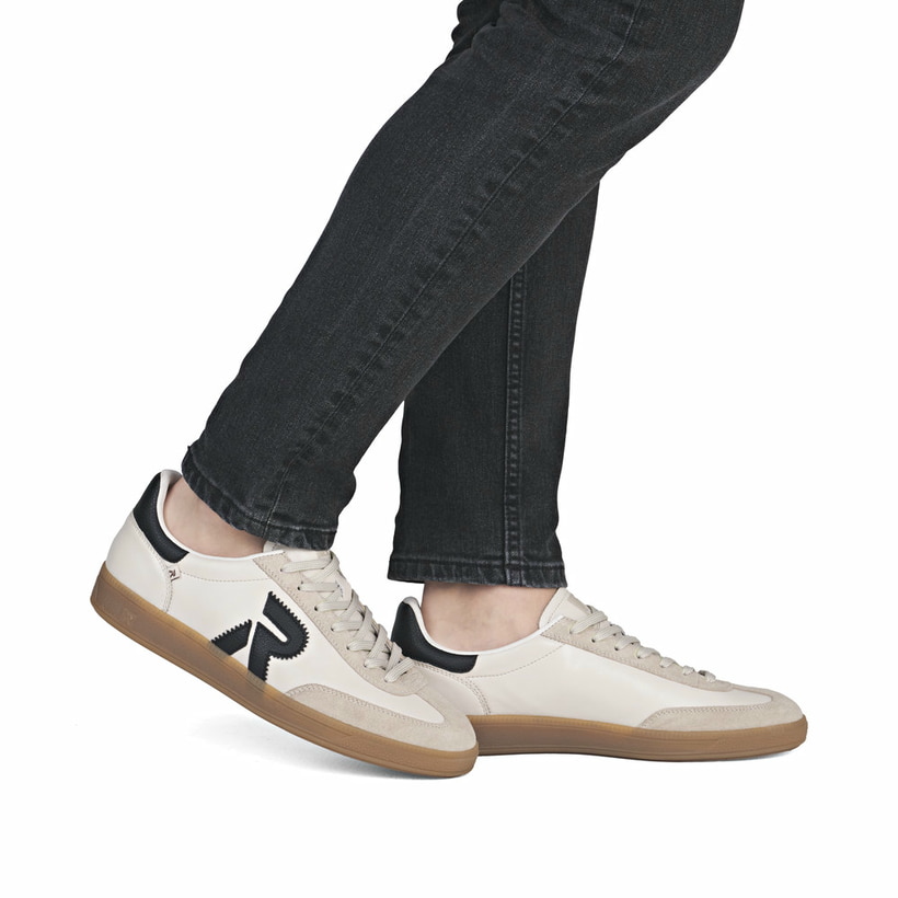 Beigeschwarze Rieker Herren Sneaker Low U2200-60 mit einer Schnürung. Schuh am Fuß.