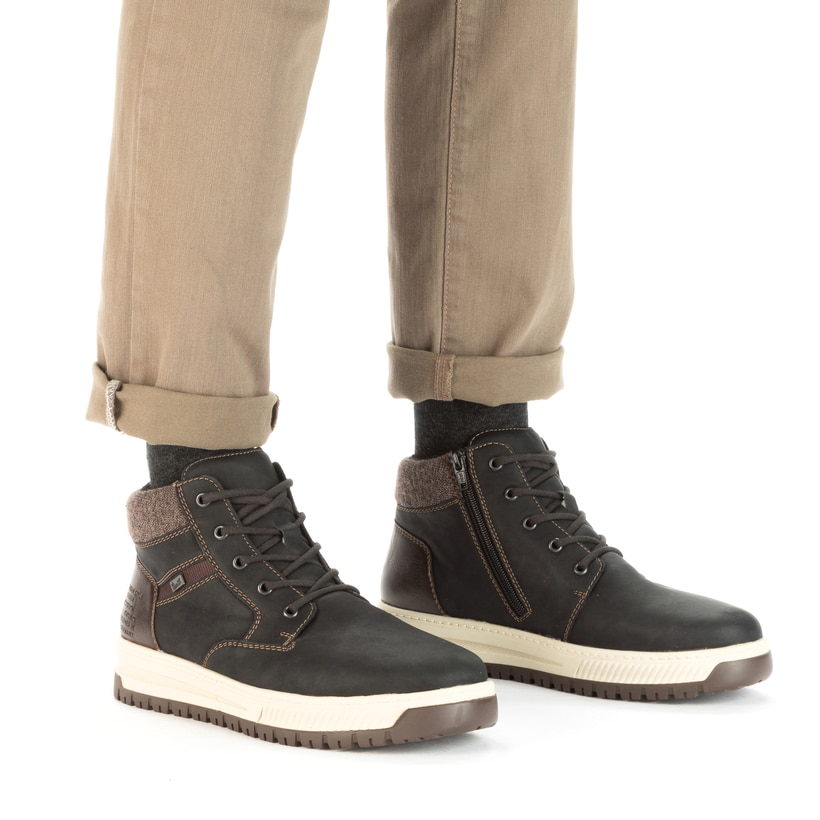 Asphaltschwarze Rieker Herren Schnürstiefel 38542-00 mit einer robusten Profilsohle. Schuh am Fuß