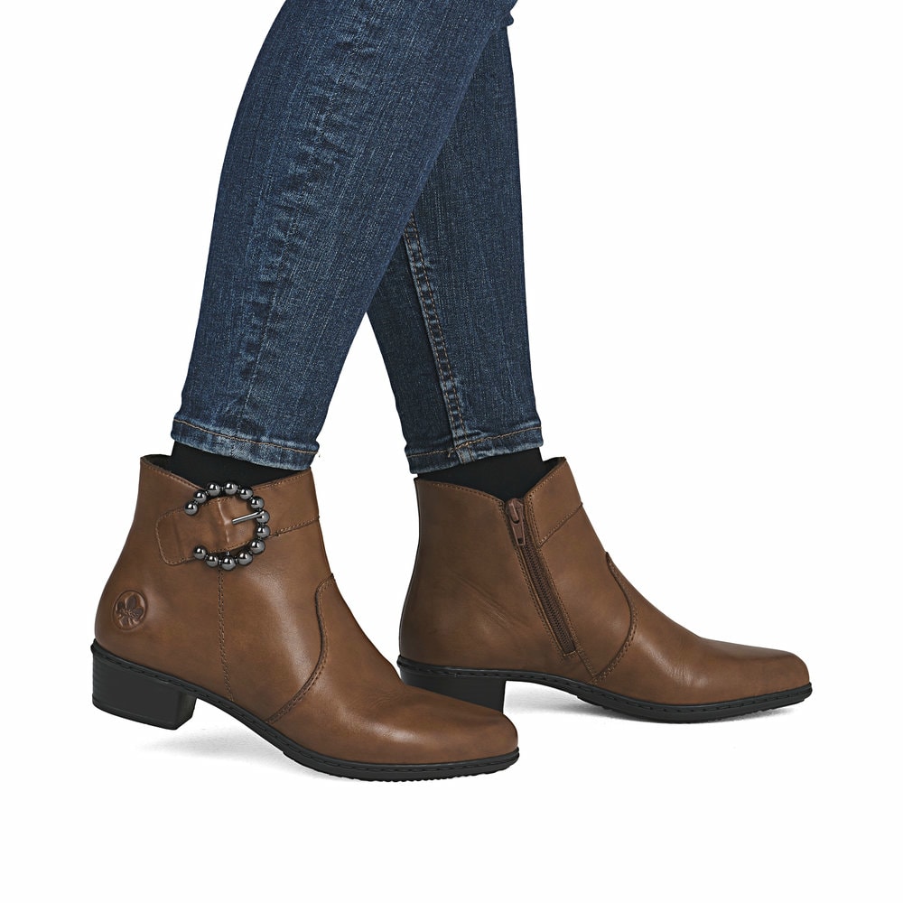 Braune Rieker Damen Stiefeletten Y0797-24 aus Glattleder mit trendiger Schnalle. Schuh am Fuß.