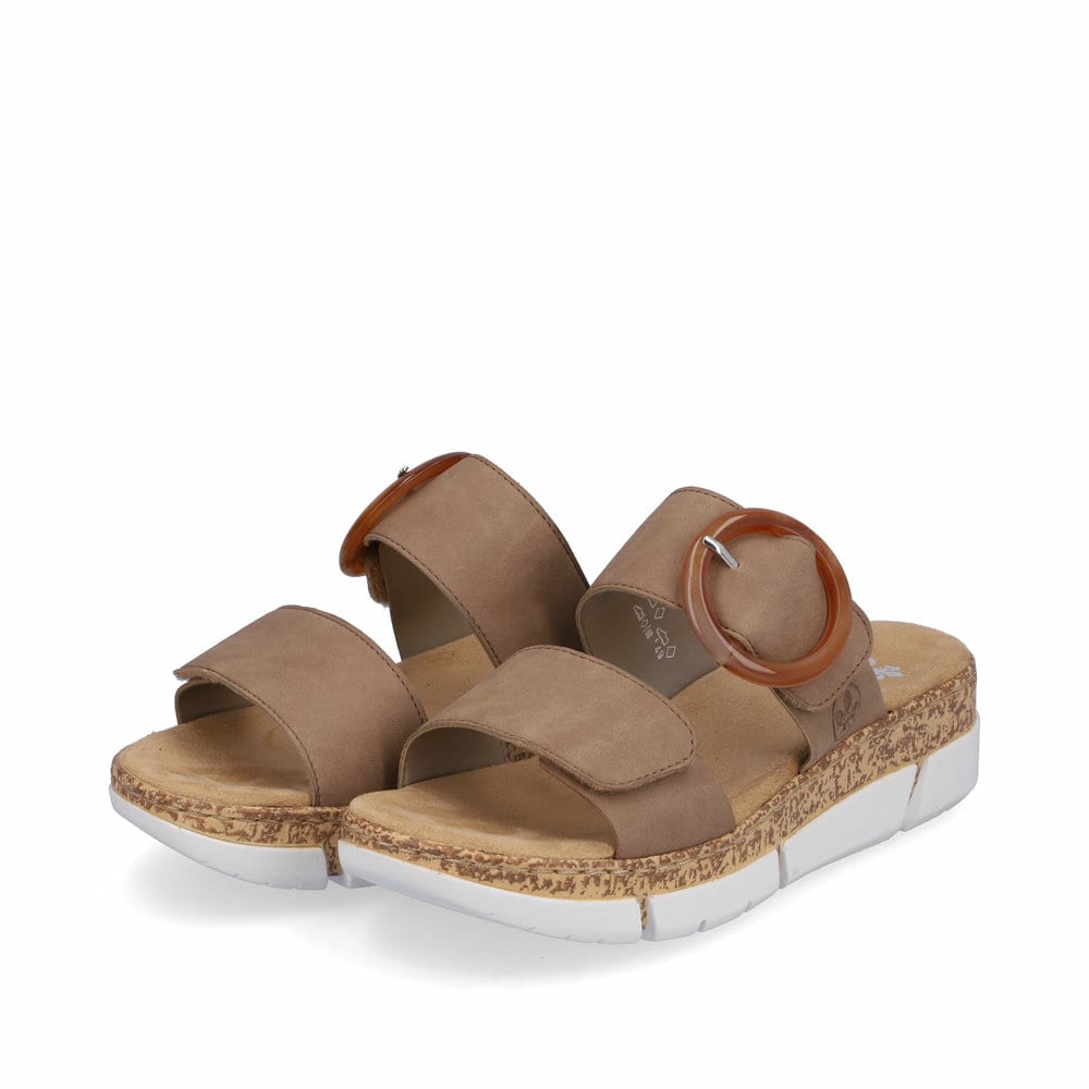 Beige vegane Rieker Damen Pantoletten V2392-62 mit trendigen Schnalle. Schuhpaar seitlich schräg.