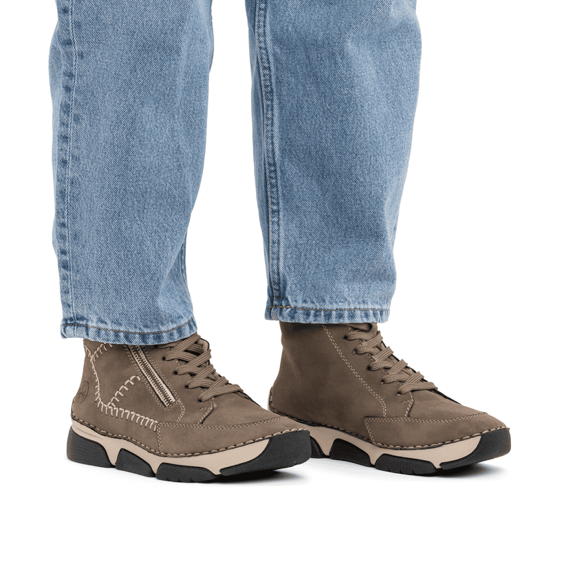 Braune Rieker Damen Schnürstiefel 45962-25 mit modernen Ziernähten. Schuh am Fuß.