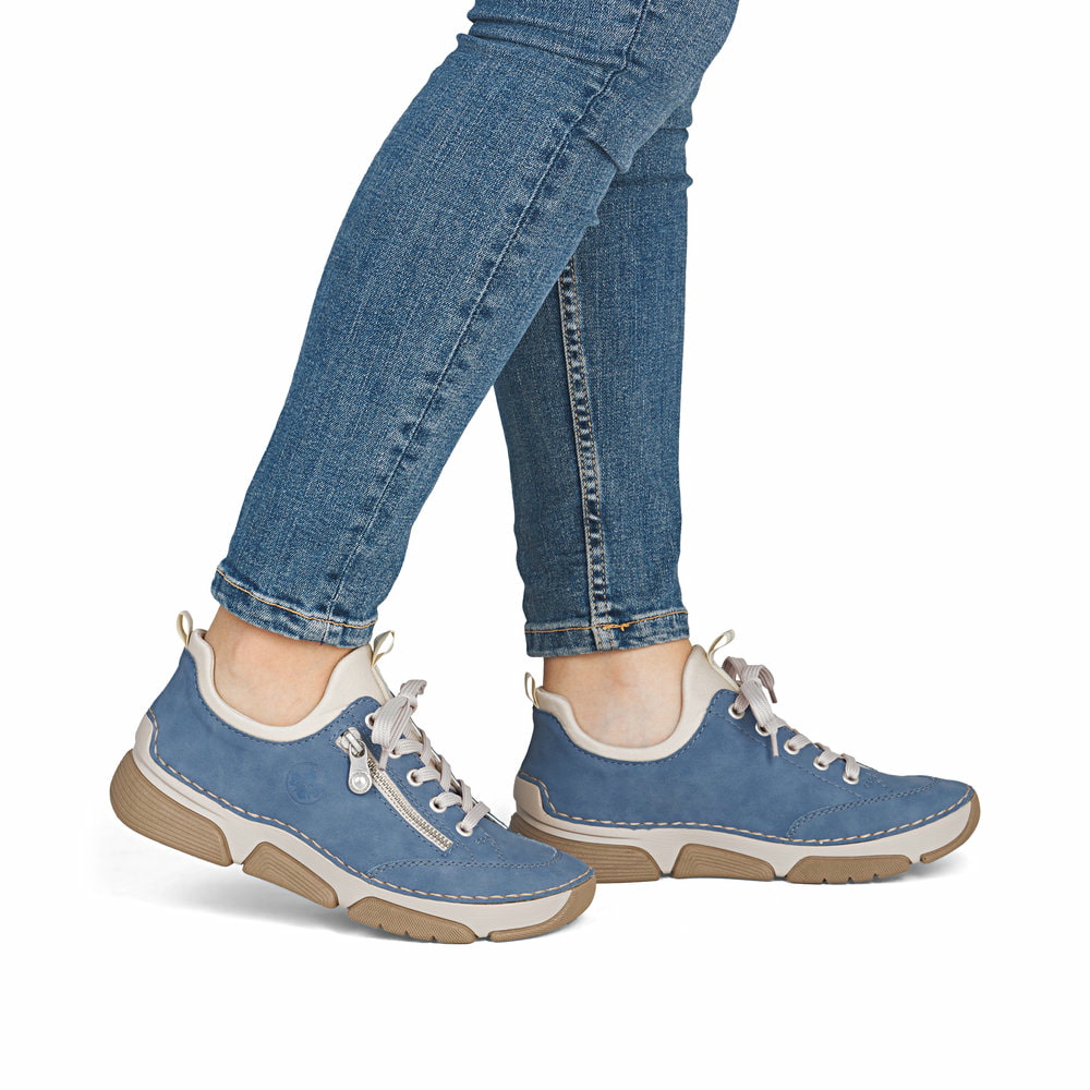 Blaue Rieker Damen Slipper 45973-14 mit Deko-Reißverschluss sowie einem Gummizug. Schuh am Fuß.