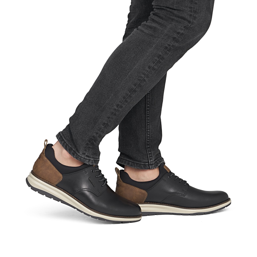 Schwarz-braune Rieker Herren Slipper 14755-00 aus Glattleder. Schuh am Fuß.