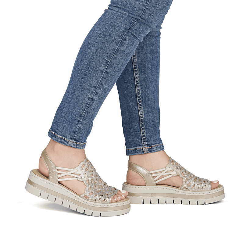 Beige Rieker Keilsandaletten V4941-60 mit Strasssteinen sowie einem Gummizug. Schuh am Fuß.