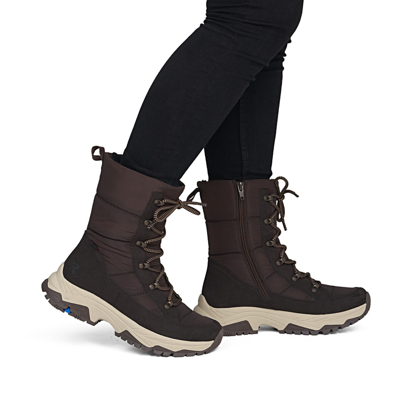 Dunkelbraune Rieker Damen Kurzstiefel Z3950-25 mit dem umdrehbaren Glacier Grip. Schuh am Fuß.