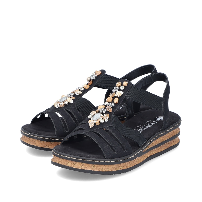 Schwarze Rieker Keilsandaletten 62949-00 mit Schmuckelementen sowie Gummizug. Schuhpaar seitlich schräg.