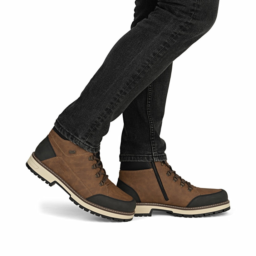 Hellbraune Rieker Herren Schnürstiefel F8302-24 mit einer Flip-Grip Sohle mit Spikes. Schuh am Fuß